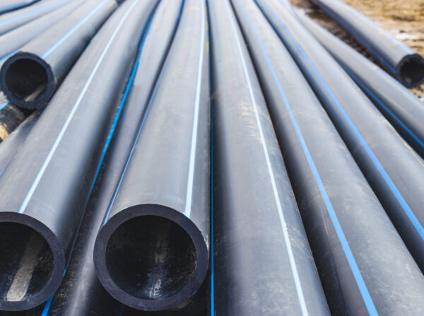 Water pipes for drinking water supply lie on the construction site. Preparation for earthworks for laying an underground pipeline. Modern water supply systems for a residential city